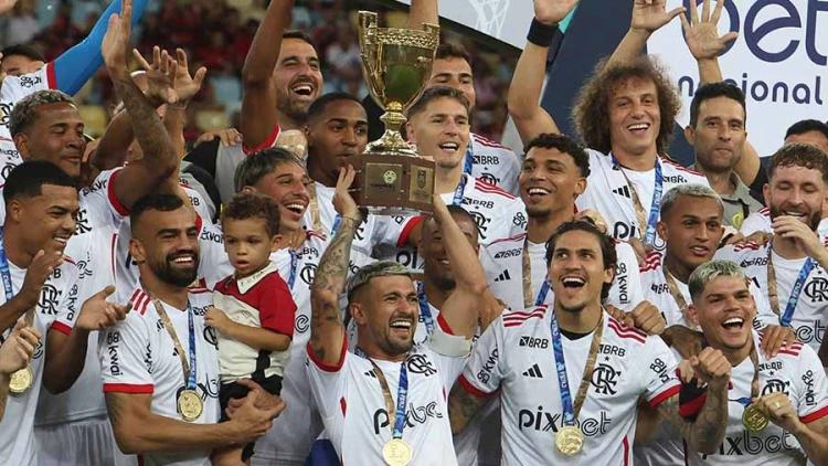 Time do Flamengo festejando a vitória no campeonato carioca 2024 com o capitão Arrascaeta erguendo a taça